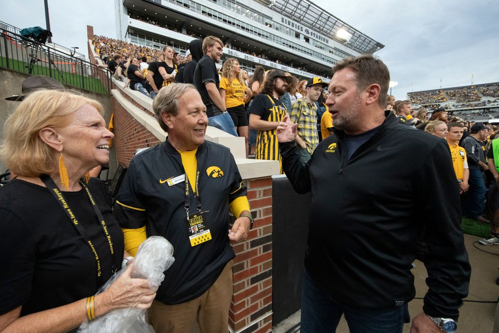 University of Iowa President Bruce Harreld and his wife talk with honorary captain Bob Stoops before the Iowa Hawkeyes game against the Miami RedHawks Saturday, August 31, 2019 at Kinnick Stadium in Iowa City. (Brian Ray/hawkeyesports.com)