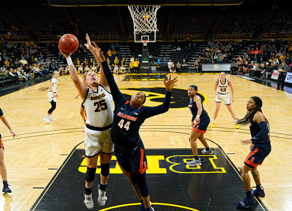 Iowa Hawkeyes forward Monika Czinano (25) scores a basket over the hand of Illinois Fighting Illini forward Kennedi Myles (44) during the third quarter of their game at Carver-Hawkeye Arena in Iowa City on Tuesday, December 31, 2019. (Stephen Mally/hawkeyesports.com)