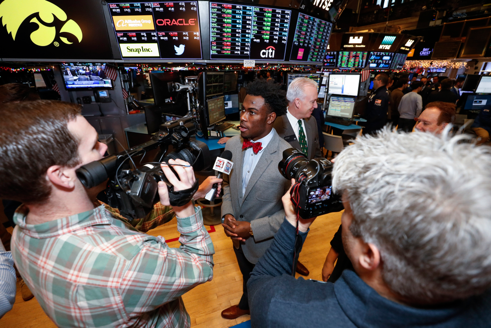 Iowa Hawkeyes linebacker Josey Jewell (43), defensive back Joshua Jackson (15), offensive lineman Sean Welsh (79) and head coach Kirk Ferentz ring the opening bell at the New York Stock Exchange Tuesday, December 26, 2017 in New York. (Brian Ray/hawkeyesports.com)