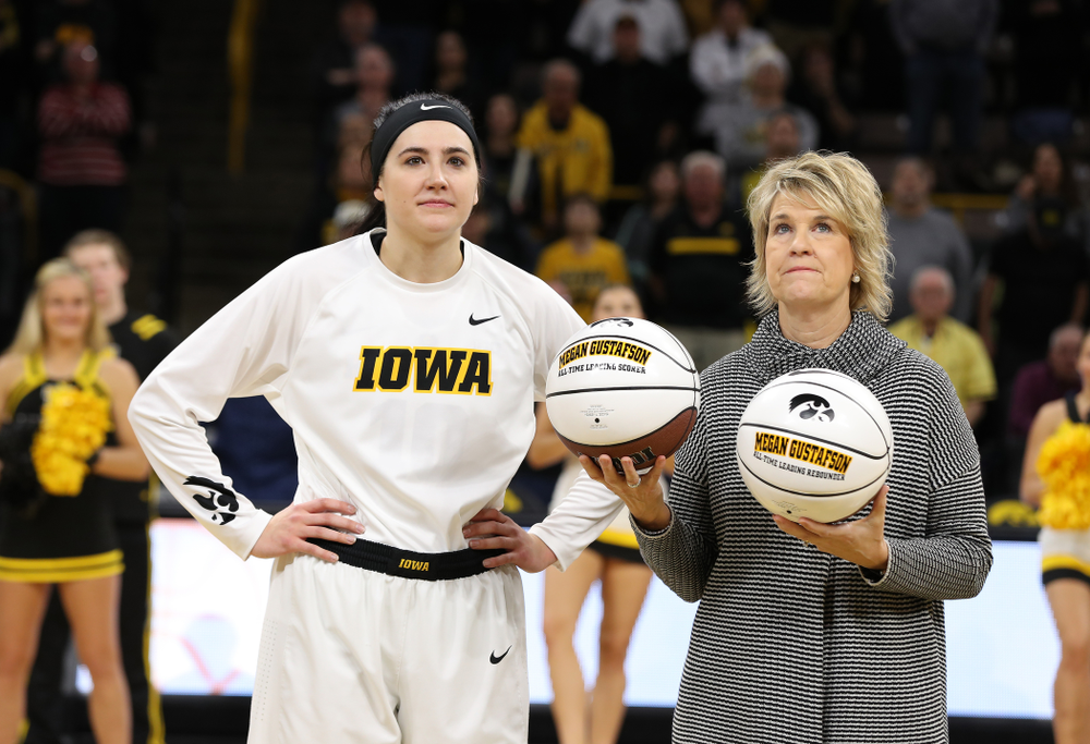 Iowa Hawkeyes forward Megan Gustafson (10) receives a pair of commemorative basketballs from head coach Lisa Bluder for becoming the school's all time rebounds leader and scoring leader before their gam eagainst the Nebraska Cornhuskers Thursday, January 3, 2019 at Carver-Hawkeye Arena. (Brian Ray/hawkeyesports.com)