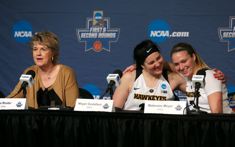 Iowa Hawkeyes forward Megan Gustafson (center) and guard Makenzie Meyer (right) hug as head coach Lisa Bluder talks during their press availability after winning their game in the first round of the 2019 NCAA Women's Basketball Tournament at Carver Hawkeye Arena in Iowa City on Friday, Mar. 22, 2019. (Stephen Mally for hawkeyesports.com)
