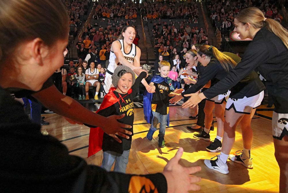 Iowa Hawkeyes forward Amanda Ollinger (43) is introduced with two Go Red for Women Movement Heart Champions before the start of their game at Carver-Hawkeye Arena in Iowa City on Sunday, January 26, 2020. (Stephen Mally/hawkeyesports.com)