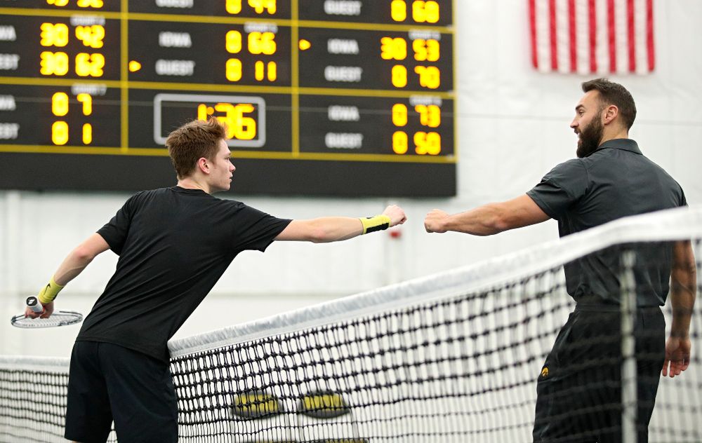 Iowa’s Jason Kerst (from left) gets a fist bump from assistant coach Lloyd Bruce-Burgess after winning his match against Marquette at the Hawkeye Tennis and Recreation Complex in Iowa City on Saturday, January 25, 2020. (Stephen Mally/hawkeyesports.com)