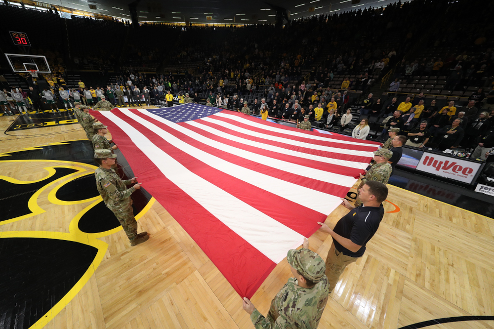 Service members stretch out a large American flag before the Iowa Hawkeyes game against UW Green Bay Sunday, November 11, 2018 at Carver-Hawkeye Arena. (Brian Ray/hawkeyesports.com)