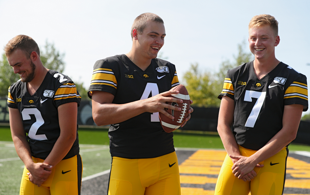 Iowa Hawkeyes quarterback Peyton Mansell (2), quarterback Nate Stanley (4), and quarterback Spencer Petras (7) laugh as they try to pose for a picture during Iowa Football Media Day at the Hansen Football Performance Center in Iowa City on Friday, Aug 9, 2019. (Stephen Mally/hawkeyesports.com)