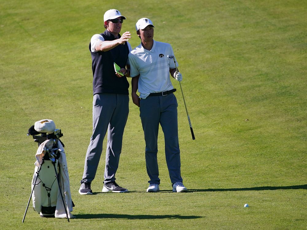Iowa assistant coach Charlie Hoyle (from left) talks with Joe Kim during the second round of the Hawkeye Invitational at Finkbine Golf Course in Iowa City on Saturday, Apr. 20, 2019. (Stephen Mally/hawkeyesports.com)