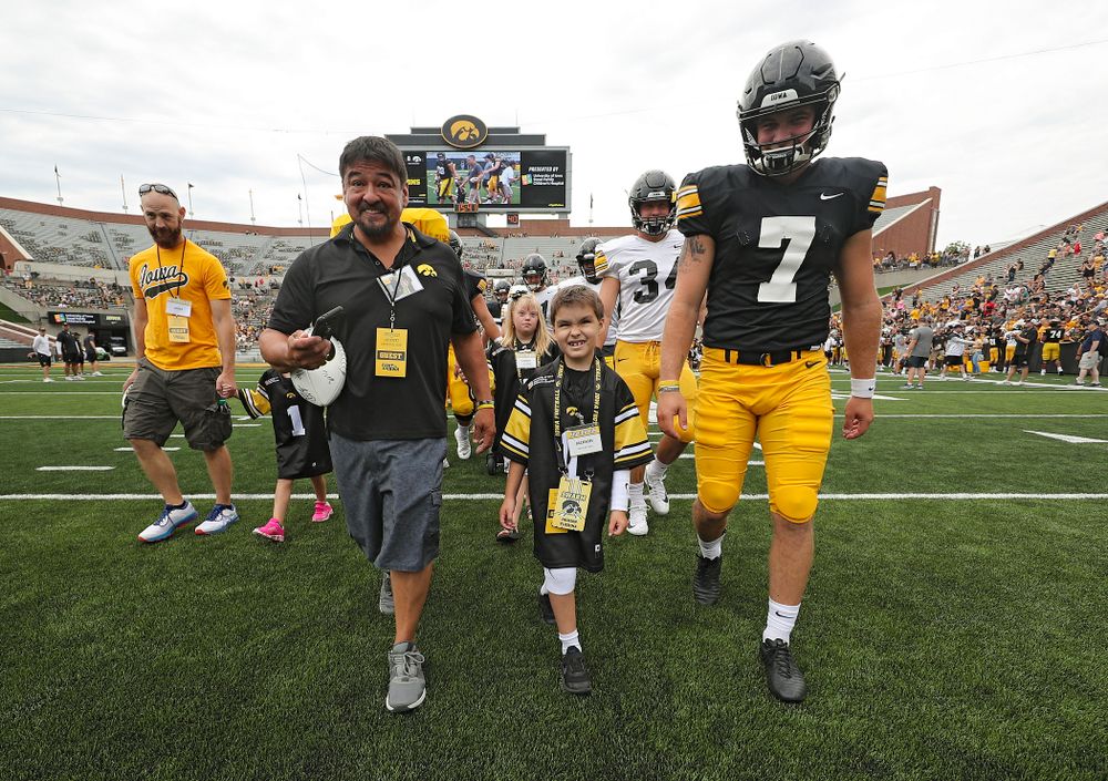 Kid Captain Jackson Tijerina swarms with Iowa Hawkeyes punter Colten Rastetter (7) during Kids Day at Kinnick Stadium in Iowa City on Saturday, Aug 10, 2019. (Stephen Mally/hawkeyesports.com)
