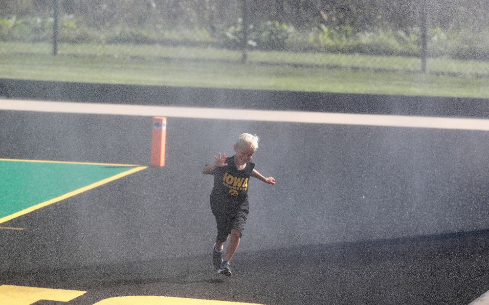 A young boy plays in the sprinklers as the field is watered at half time of the Iowa Hawkeyes game against the Penn Quakers Friday, September 14, 2018 at Grant Field. (Brian Ray/hawkeyesports.com)