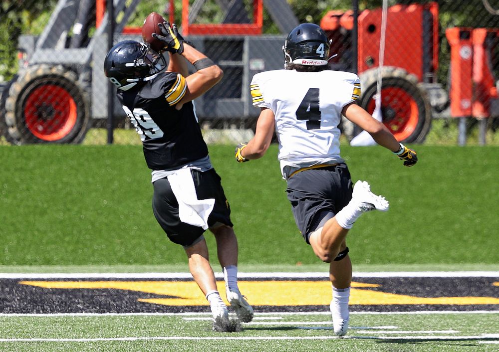 Iowa Hawkeyes wide receiver Nico Ragaini (89) pulls in a pass for a touchdown as defensive back Dane Belton (4) gives chase during Fall Camp Practice No. 7 at the Hansen Football Performance Center in Iowa City on Friday, Aug 9, 2019. (Stephen Mally/hawkeyesports.com)