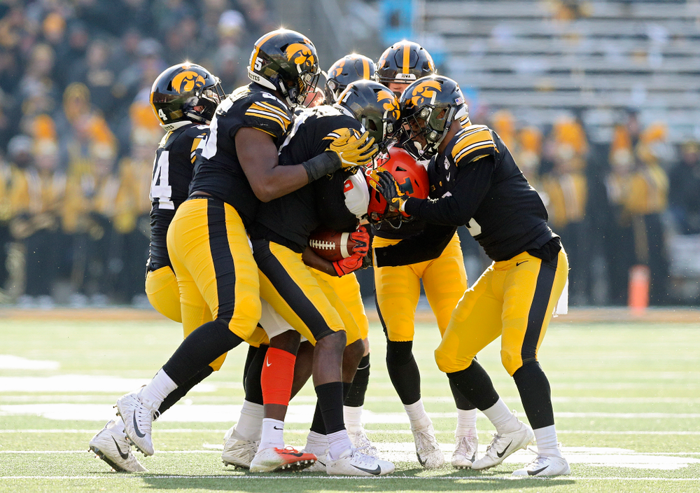 Iowa Hawkeyes linebacker Kristian Welch (34), defensive lineman Cedrick Lattimore (95), defensive back Dane Belton (4), defensive back Michael Ojemudia (11), defensive back Jack Koerner (28), and defensive back Geno Stone (9) stop Illinois Fighting Illini wide receiver Josh Imatorbhebhe (9) during the second quarter of their game at Kinnick Stadium in Iowa City on Saturday, Nov 23, 2019. (Stephen Mally/hawkeyesports.com)