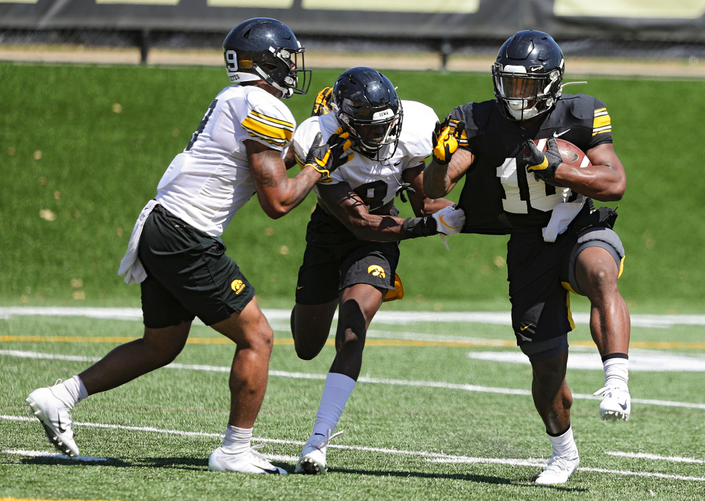 Iowa Hawkeyes defensive back Geno Stone (from left) and defensive back Matt Hankins close in on running back Mekhi Sargent (10) during Fall Camp Practice No. 7 at the Hansen Football Performance Center in Iowa City on Friday, Aug 9, 2019. (Stephen Mally/hawkeyesports.com)