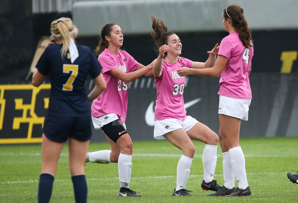 Iowa Hawkeyes midfielder Josie Durr (25), Iowa Hawkeyes forward Devin Burns (30) and Iowa Hawkeyes forward Kaleigh Haus (4) celebrate after Burns' second half goal during a game against Michigan at the Iowa Soccer Complex on October 14, 2018. (Tork Mason/hawkeyesports.com)