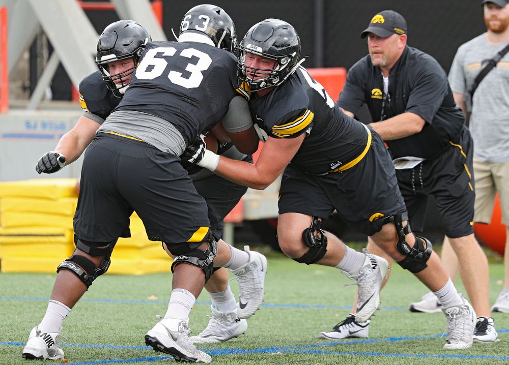 Iowa Hawkeyes offensive lineman Nick DeJong (left) and offensive lineman Ezra Miller (right) block offensive lineman Justin Britt (center) as they run a drill with offensive line coach Tim Polasek during Fall Camp Practice No. 15 at the Hansen Football Performance Center in Iowa City on Monday, Aug 19, 2019. (Stephen Mally/hawkeyesports.com)