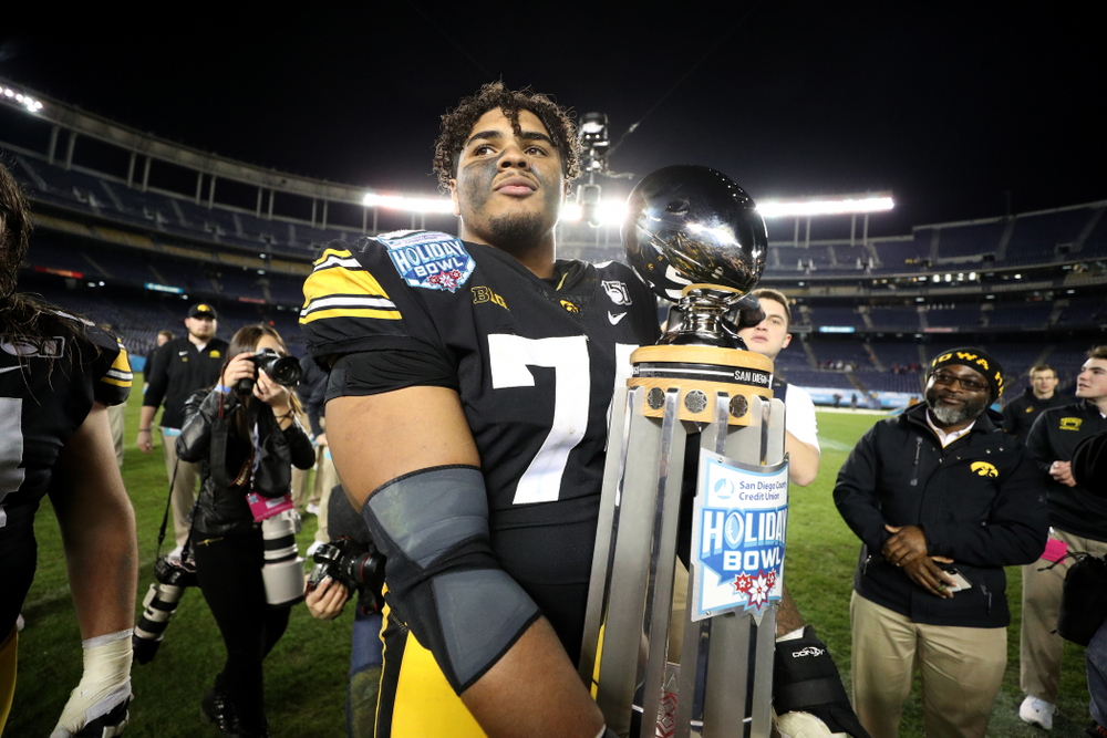 Iowa Hawkeyes offensive lineman Tristan Wirfs (74) celebrates with the Holiday Bowl trophy following their win against USC in the Holiday Bowl Friday, December 27, 2019 at San Diego Community Credit Union Stadium. (Brian Ray/hawkeyesports.com)