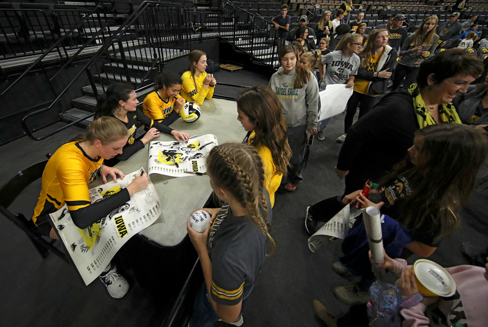 Iowa’s Hannah Clayton (18), Halle Johnston (4), Brie Orr (7), and Meghan Buzzerio (5) sign autographs after their match at Carver-Hawkeye Arena in Iowa City on Sunday, Oct 20, 2019. (Stephen Mally/hawkeyesports.com)
