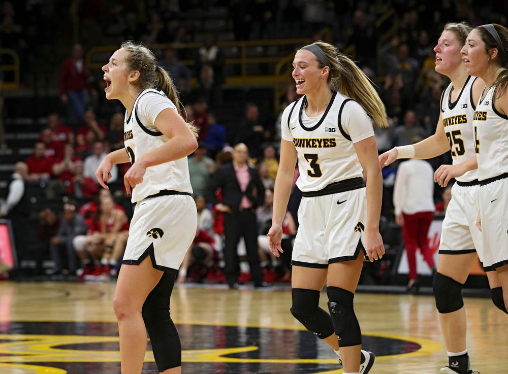 Iowa Hawkeyes guard Kathleen Doyle (22) celebrates with guard Makenzie Meyer (3), forward Monika Czinano (25), and guard Mckenna Warnock (14), after making a basket while being fouled during the fourth quarter of their game at Carver-Hawkeye Arena in Iowa City on Sunday, January 12, 2020. (Stephen Mally/hawkeyesports.com)