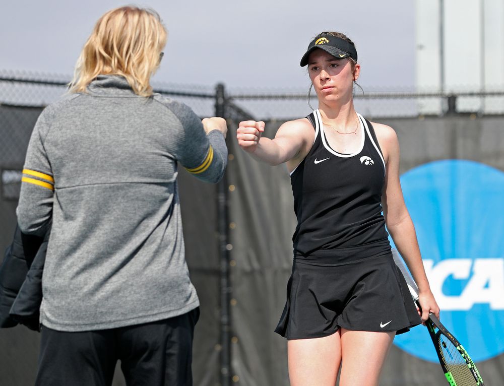 Iowa head coach Sasha Schmid (from left) fist bumps Samantha Mannix during a match against Rutgers at the Hawkeye Tennis and Recreation Complex in Iowa City on Friday, Apr. 5, 2019. (Stephen Mally/hawkeyesports.com)