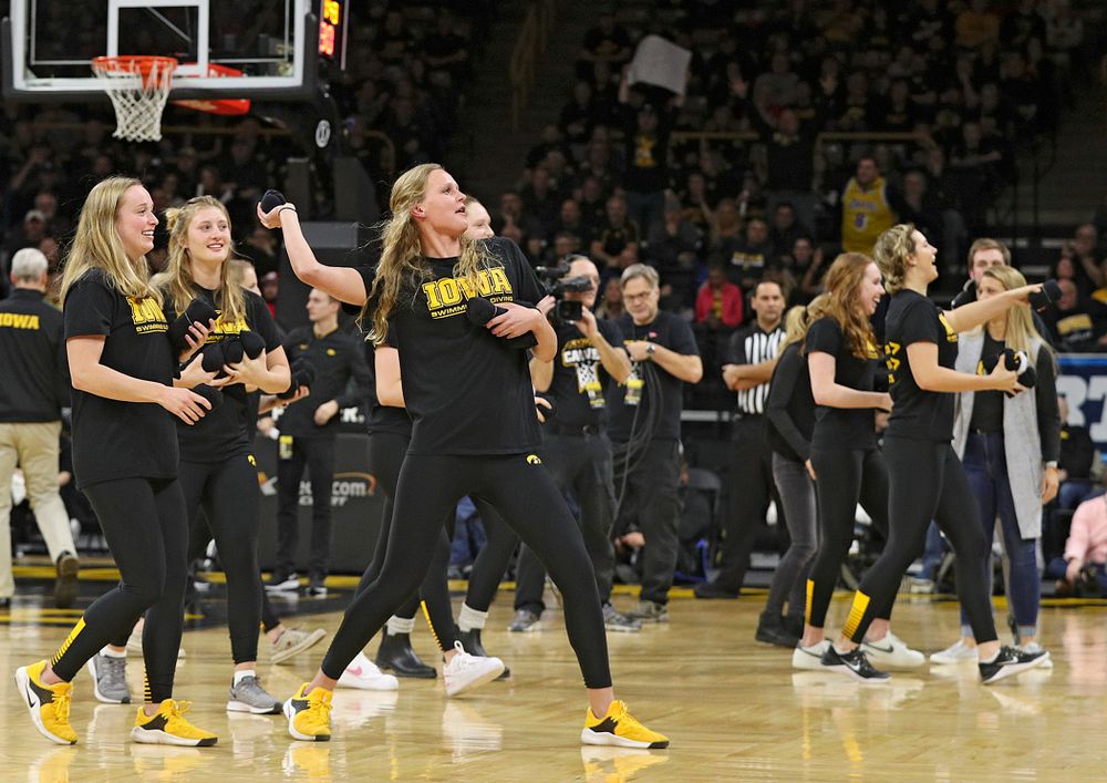 Iowa swimming and diving student-athletes throw t-shirts into the crowd during a timeout in the first half of their game at Carver-Hawkeye Arena in Iowa City on Monday, January 27, 2020. (Stephen Mally/hawkeyesports.com)