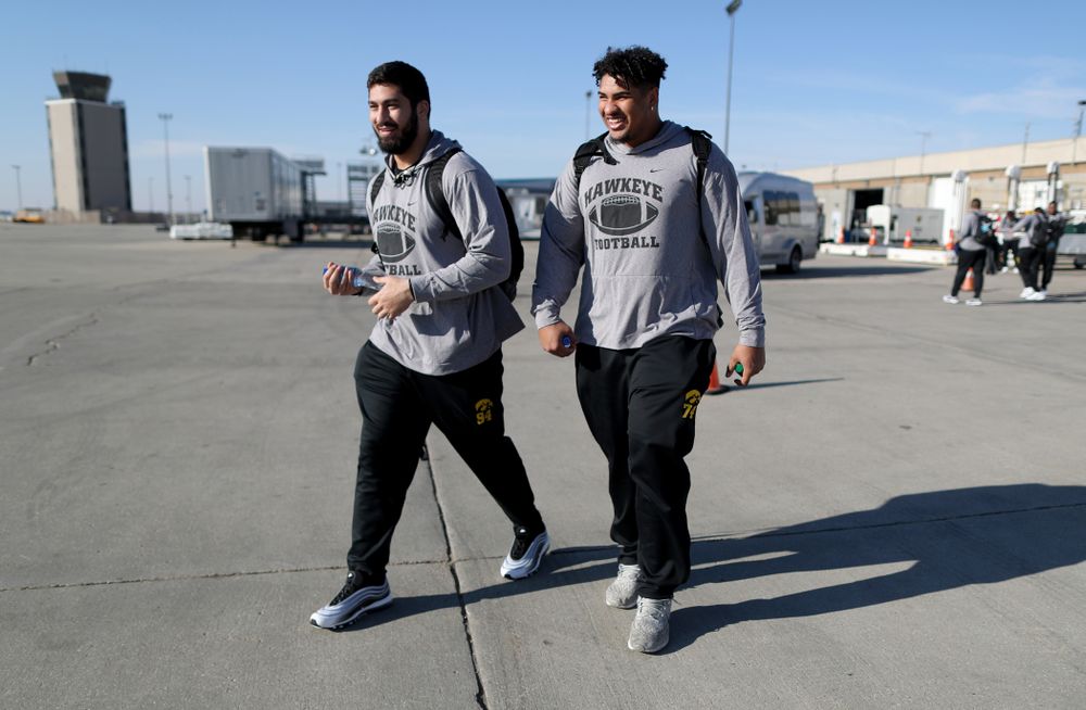 Iowa Hawkeyes defensive end A.J. Epenesa (94) and offensive lineman Tristan Wirfs (74) board the team plane at the Eastern Iowa Airport Saturday, December 21, 2019 on the way to San Diego, CA for the Holiday Bowl. (Brian Ray/hawkeyesports.com)