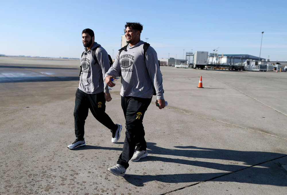 Iowa Hawkeyes defensive end A.J. Epenesa (94) and offensive lineman Tristan Wirfs (74) board the team plane at the Eastern Iowa Airport Saturday, December 21, 2019 on the way to San Diego, CA for the Holiday Bowl. (Brian Ray/hawkeyesports.com)
