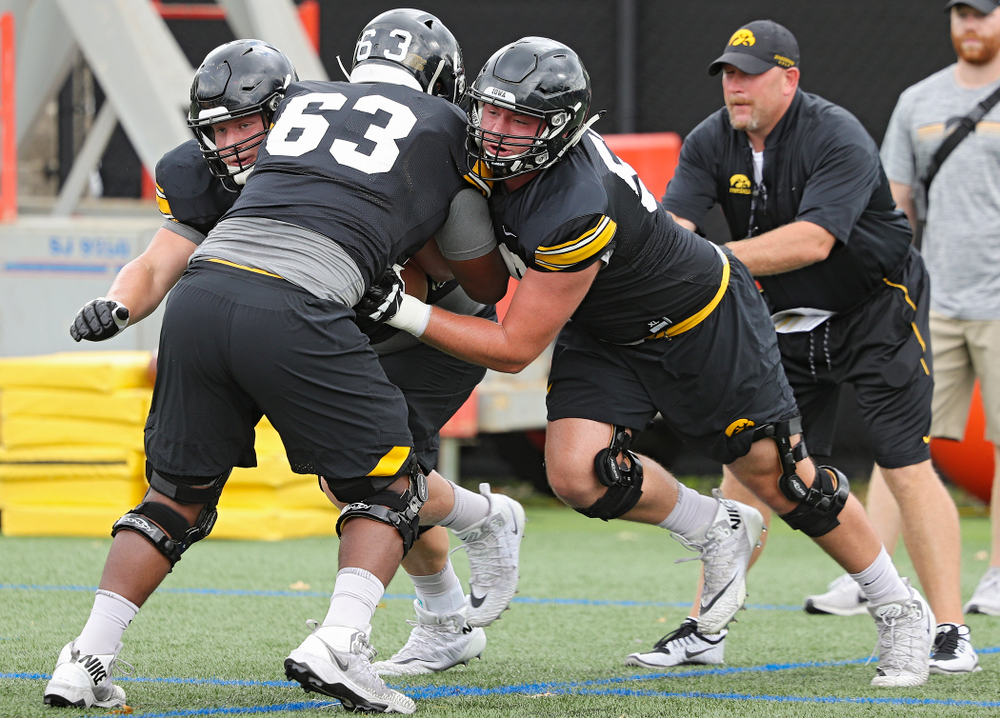 Iowa Hawkeyes offensive lineman Nick DeJong (left) and offensive lineman Ezra Miller (right) block offensive lineman Justin Britt (center) as they run a drill with offensive line coach Tim Polasek during Fall Camp Practice No. 15 at the Hansen Football Performance Center in Iowa City on Monday, Aug 19, 2019. (Stephen Mally/hawkeyesports.com)