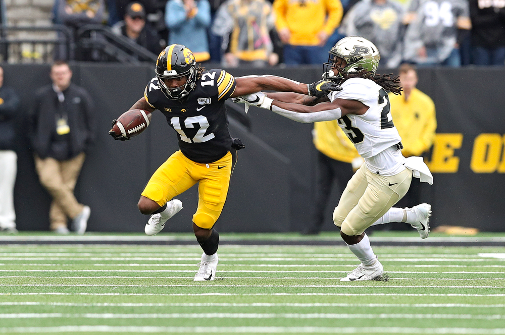 Iowa Hawkeyes wide receiver Brandon Smith (12) pulls away from a defender after making a catch during the first quarter of their game at Kinnick Stadium in Iowa City on Saturday, Oct 19, 2019. (Stephen Mally/hawkeyesports.com)