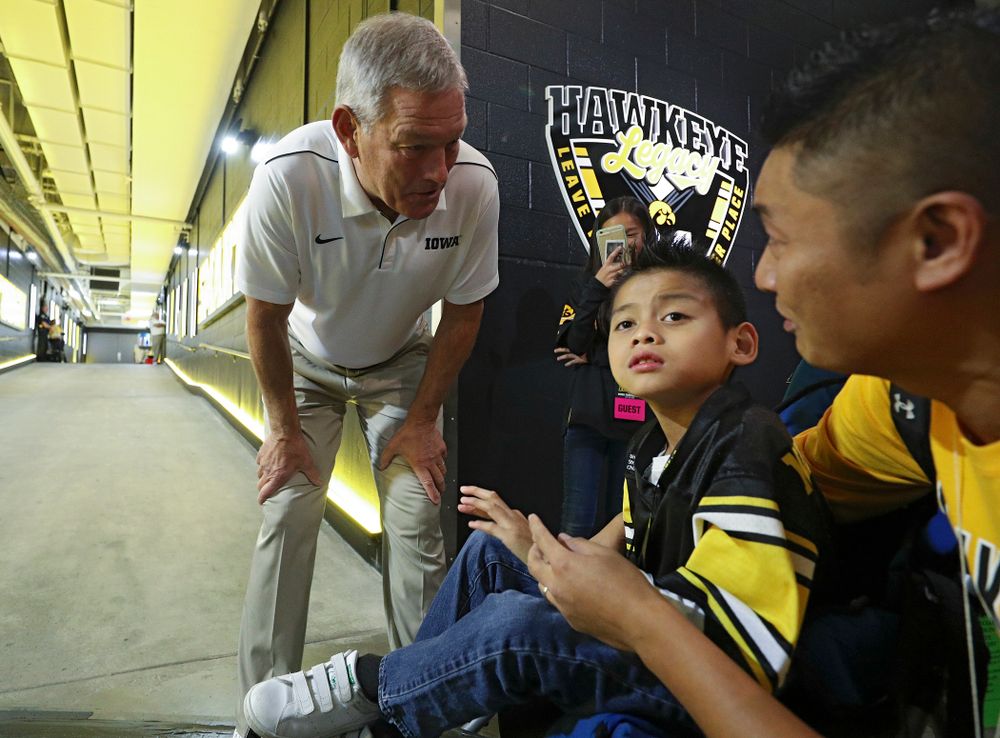 Iowa Hawkeyes head coach Kirk Ferentz talks with Kid Captain Enzo Thongsoum before their game at Kinnick Stadium in Iowa City on Saturday, Sep 28, 2019. (Stephen Mally/hawkeyesports.com)