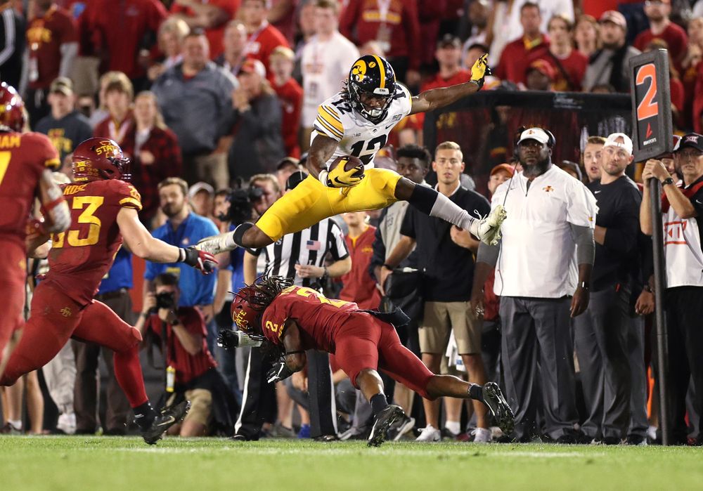 Iowa Hawkeyes wide receiver Brandon Smith (12) hurdles a defender against the Iowa State Cyclones Saturday, September 14, 2019 in Ames, Iowa. (Brian Ray/hawkeyesports.com)