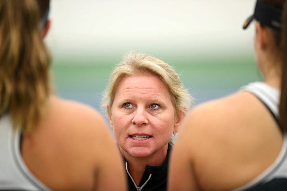 Iowa head coach Sasha Schmid (center) talks with Ashleigh Jacobs (left) and Danielle Bauers (right) during their doubles match at the Hawkeye Tennis and Recreation Complex in Iowa City on Sunday, February 16, 2020. (Stephen Mally/hawkeyesports.com)