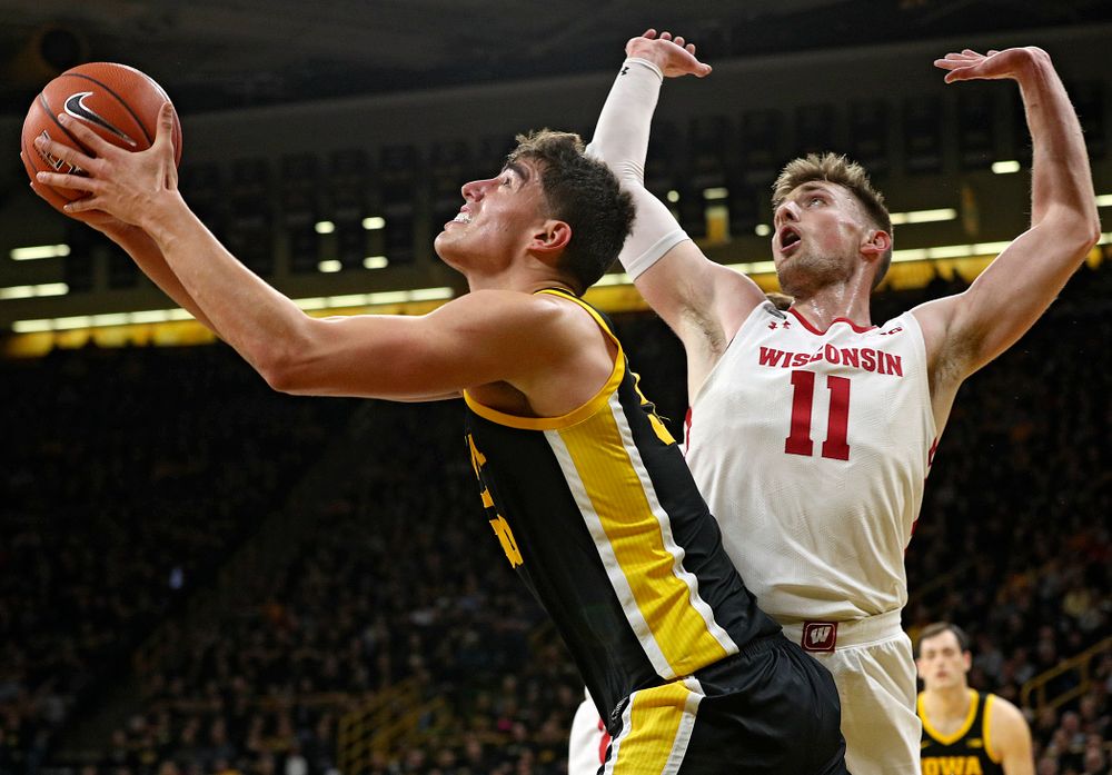 Iowa Hawkeyes center Luka Garza (55) puts up a shot around Wisconsin Badgers forward Micah Potter (11) during the first half of their game at Carver-Hawkeye Arena in Iowa City on Monday, January 27, 2020. (Stephen Mally/hawkeyesports.com)