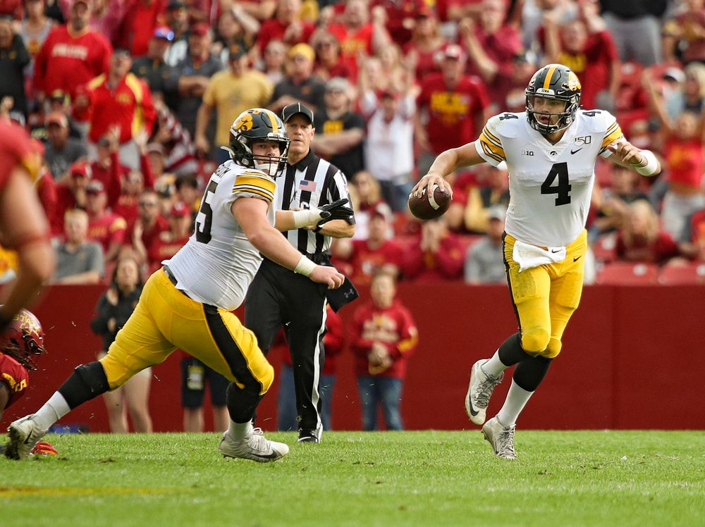Iowa Hawkeyes quarterback Nate Stanley (4) scrambles as offensive lineman Tyler Linderbaum (65) looks to block during the second quarter of their Iowa Corn Cy-Hawk Series game at Jack Trice Stadium in Ames on Saturday, Sep 14, 2019. (Stephen Mally/hawkeyesports.com)