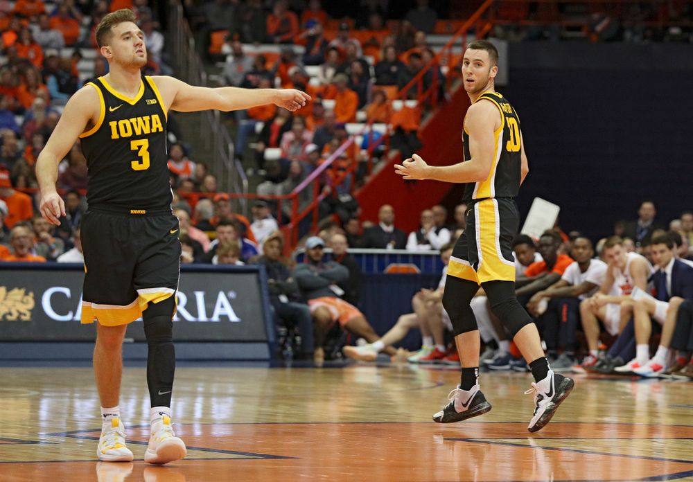 Iowa Hawkeyes guard Connor McCaffery (30) holds up three fingers after making a 3-pointer while guard Jordan Bohannon (3) directs his teammates on defense during the second half of their ACC/Big Ten Challenge game at the Carrier Dome in Syracuse, N.Y. on Tuesday, Dec 3, 2019. (Stephen Mally/hawkeyesports.com)