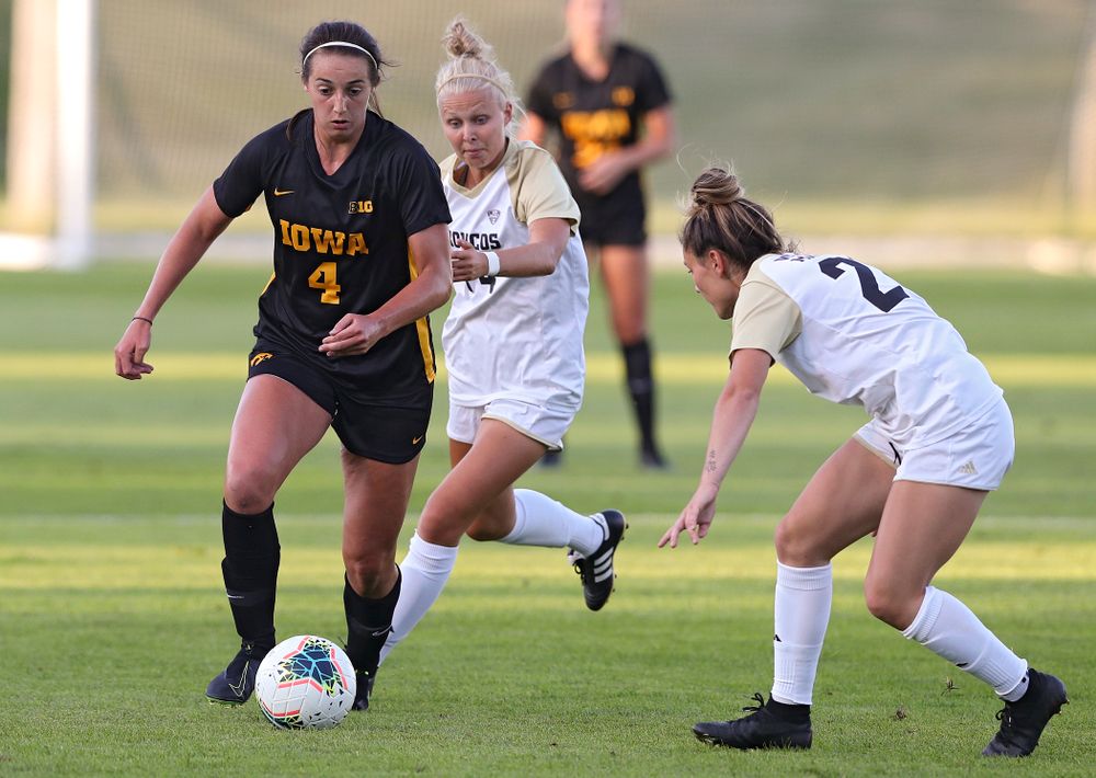 Iowa forward Kaleigh Haus (4) moves the ball around two defenders during the first half of their match against Western Michigan at the Iowa Soccer Complex in Iowa City on Thursday, Aug 22, 2019. (Stephen Mally/hawkeyesports.com)