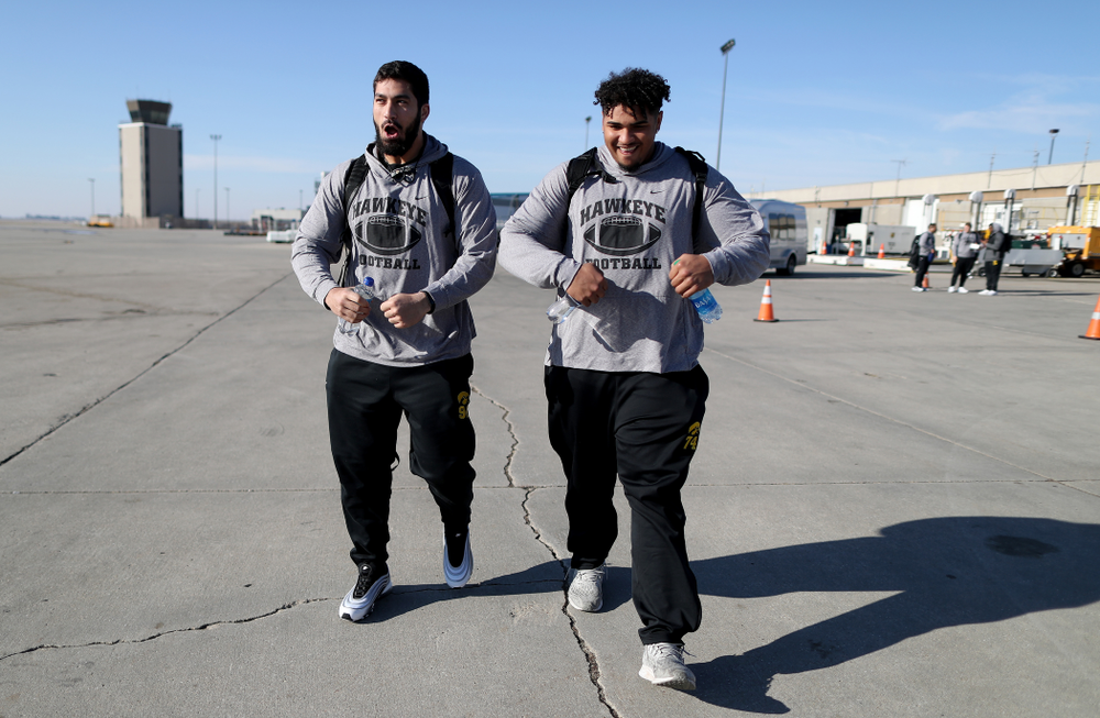 Iowa Hawkeyes defensive end A.J. Epenesa (94) and offensive lineman Tristan Wirfs (74) board the team plane at the Eastern Iowa Airport Saturday, December 21, 2019 on the way to San Diego, CA for the Holiday Bowl. (Brian Ray/hawkeyesports.com)