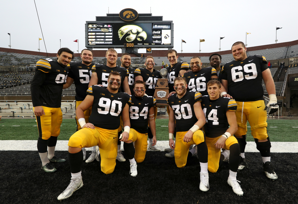 The Iowa Hawkeyes celebrate with the Heroes game trophy following their win against the Nebraska Cornhuskers Friday, November 23, 2018 at Kinnick Stadium. (Brian Ray/hawkeyesports.com)