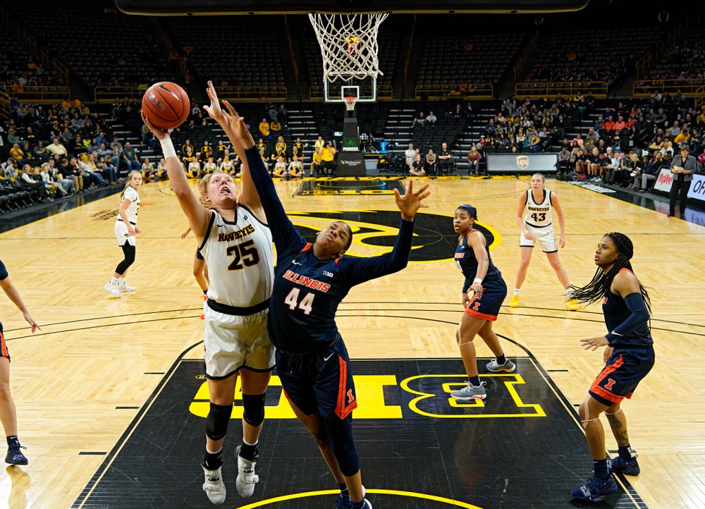 Iowa Hawkeyes forward Monika Czinano (25) scores a basket over the hand of Illinois Fighting Illini forward Kennedi Myles (44) during the third quarter of their game at Carver-Hawkeye Arena in Iowa City on Tuesday, December 31, 2019. (Stephen Mally/hawkeyesports.com)