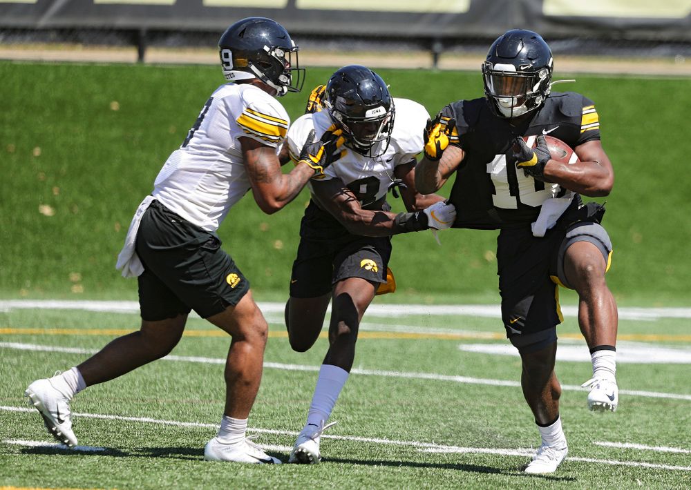Iowa Hawkeyes defensive back Geno Stone (from left) and defensive back Matt Hankins close in on running back Mekhi Sargent (10) during Fall Camp Practice No. 7 at the Hansen Football Performance Center in Iowa City on Friday, Aug 9, 2019. (Stephen Mally/hawkeyesports.com)