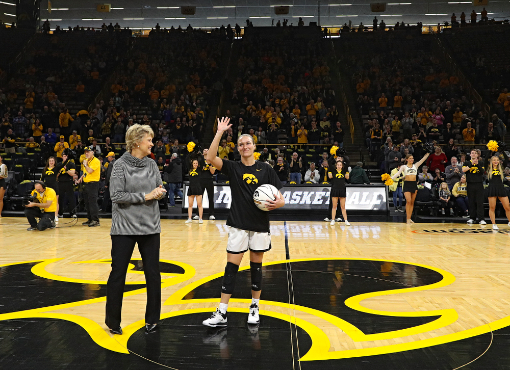 Iowa Hawkeyes head coach Lisa Bluder presents guard Makenzie Meyer (3) with a ball to honor her for scoring 1,000 career points before their game at Carver-Hawkeye Arena in Iowa City on Tuesday, December 31, 2019. (Stephen Mally/hawkeyesports.com)