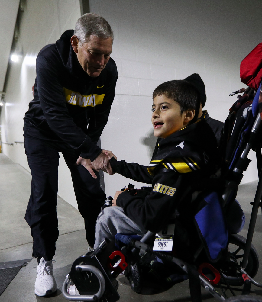 Iowa Hawkeyes head coach Kirk Ferentz shakes hands with Kid Captain Mason Gonzalez before a game against Northwestern at Kinnick Stadium on November 10, 2018. (Tork Mason/hawkeyesports.com)