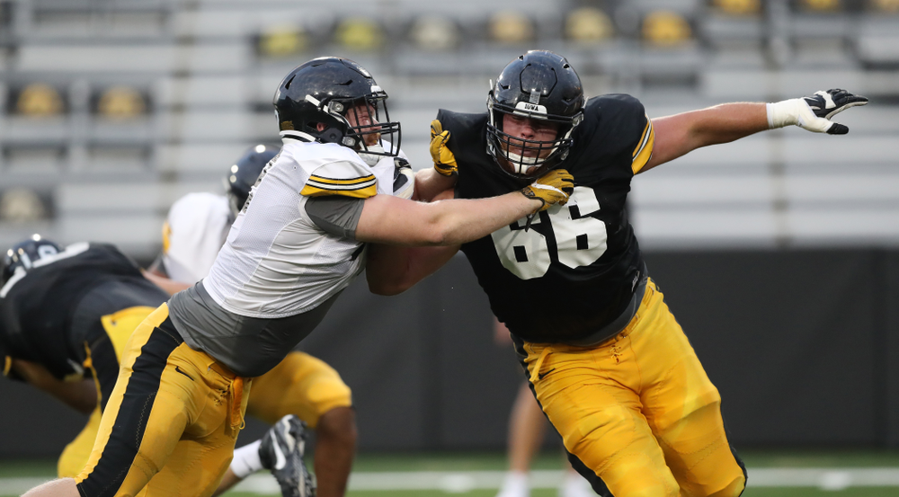 Iowa Hawkeyes defensive lineman John Waggoner (92) takes on Iowa Hawkeyes offensive lineman Levi Paulsen (66)