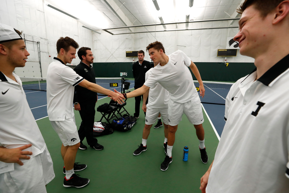 Iowa's Piotr Smietana celebrates with his teammates after clinching the match against Purdue Sunday, April 15, 2018 at the Hawkeye Tennis an
