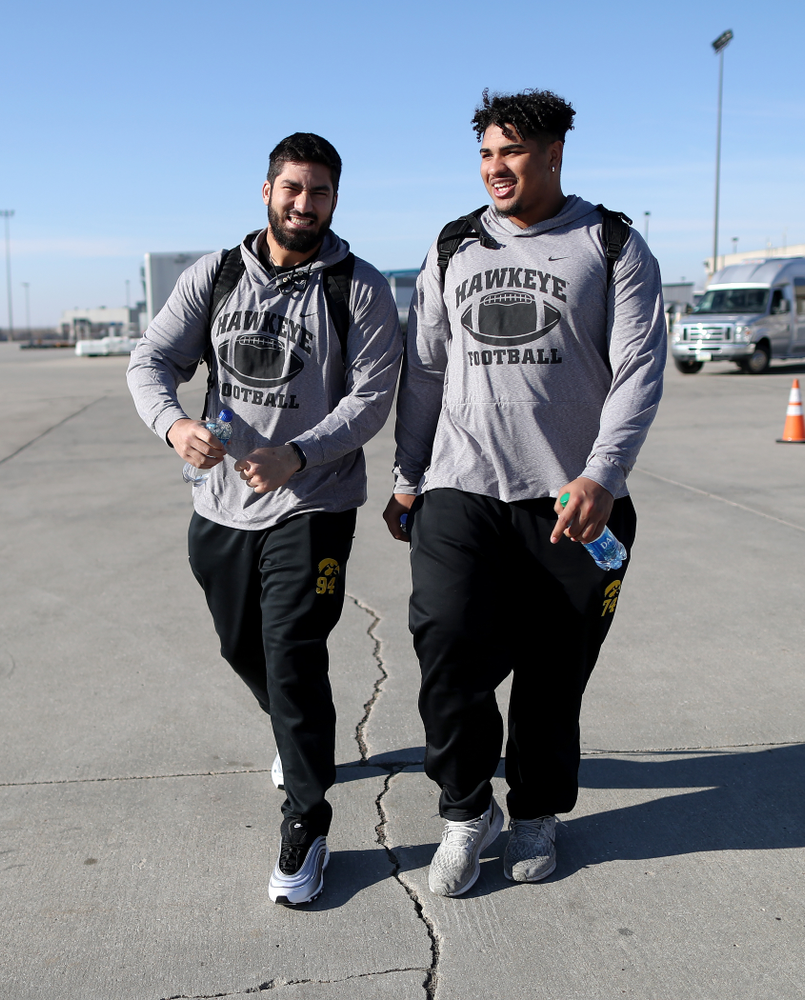 Iowa Hawkeyes defensive end A.J. Epenesa (94) and offensive lineman Tristan Wirfs (74) board the team plane at the Eastern Iowa Airport Saturday, December 21, 2019 on the way to San Diego, CA for the Holiday Bowl. (Brian Ray/hawkeyesports.com)
