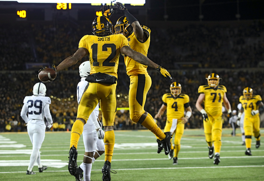 Iowa Hawkeyes wide receiver Brandon Smith (12) celebrates his touchdown reception with running back Tyler Goodson (15) during the fourth quarter of their game at Kinnick Stadium in Iowa City on Saturday, Oct 12, 2019. (Stephen Mally/hawkeyesports.com)