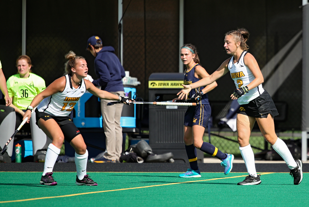 Iowa’s Leah Zellner (13) hands Emily Deuell (2) her stick during the second quarter of their game at Grant Field in Iowa City on Friday, Sep 13, 2019. (Stephen Mally/hawkeyesports.com)