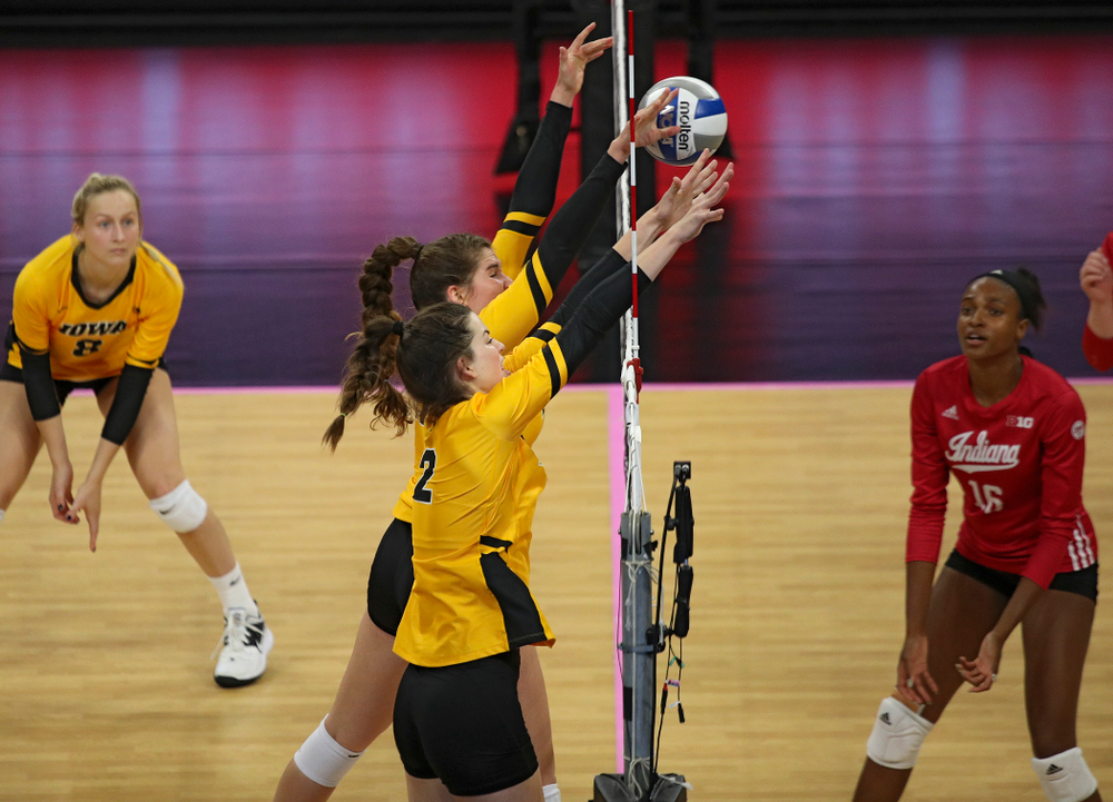 Iowa’s Blythe Rients (11) gets her hands on a shot as Courtney Buzzerio (2) looks on during their match at Carver-Hawkeye Arena in Iowa City on Sunday, Oct 20, 2019. (Stephen Mally/hawkeyesports.com)