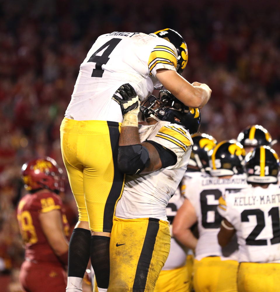 Iowa Hawkeyes quarterback Nate Stanley (4) celebrates with offensive lineman Tristan Wirfs (74) after scoring against the Iowa State Cyclones Saturday, September 14, 2019 in Ames, Iowa. (Brian Ray/hawkeyesports.com)