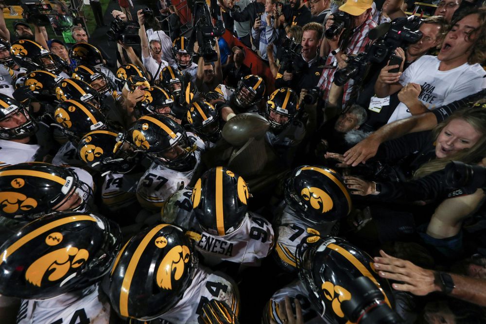 The Iowa Hawkeyes swarm to the Cy-Hawk trophy following their game against the Iowa State Cyclones Saturday, September 14, 2019 in Ames, Iowa. (Brian Ray/hawkeyesports.com)