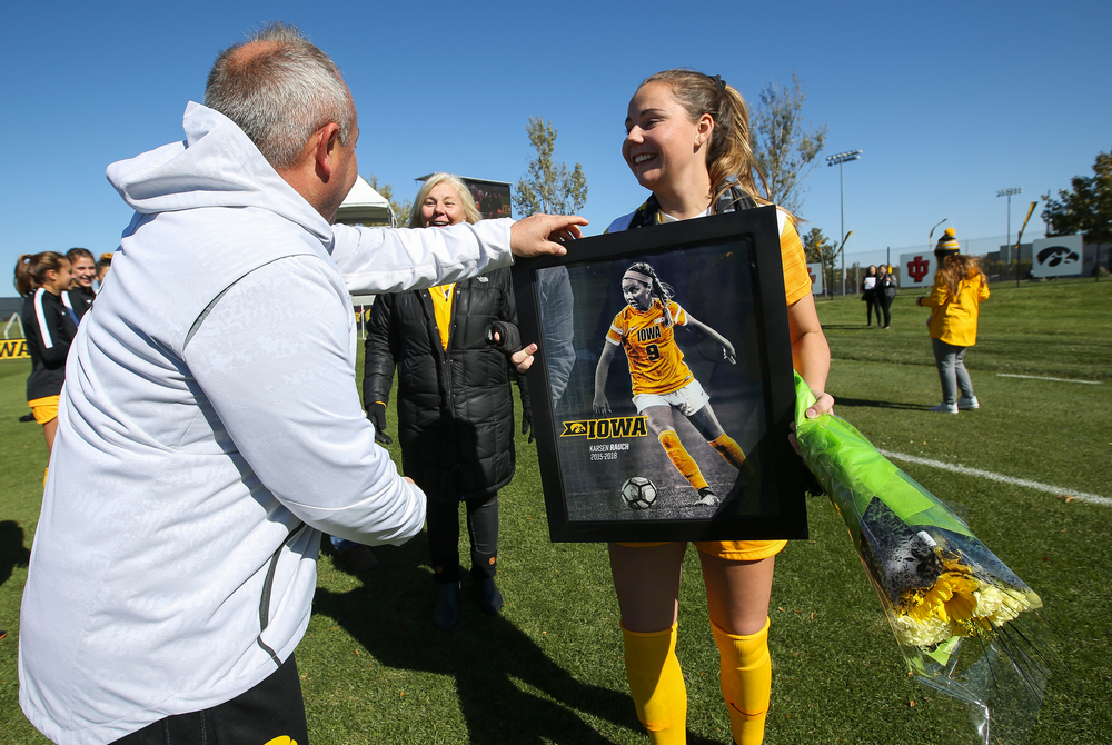 Iowa Hawkeyes head coach Dave DiIanni presents Iowa Hawkeyes defender Karsen Rauch (9) with a framed photo during Senior Day ceremonies before a game against Northwestern at the Iowa Soccer Complex on October 21, 2018. (Tork Mason/hawkeyesports.com)