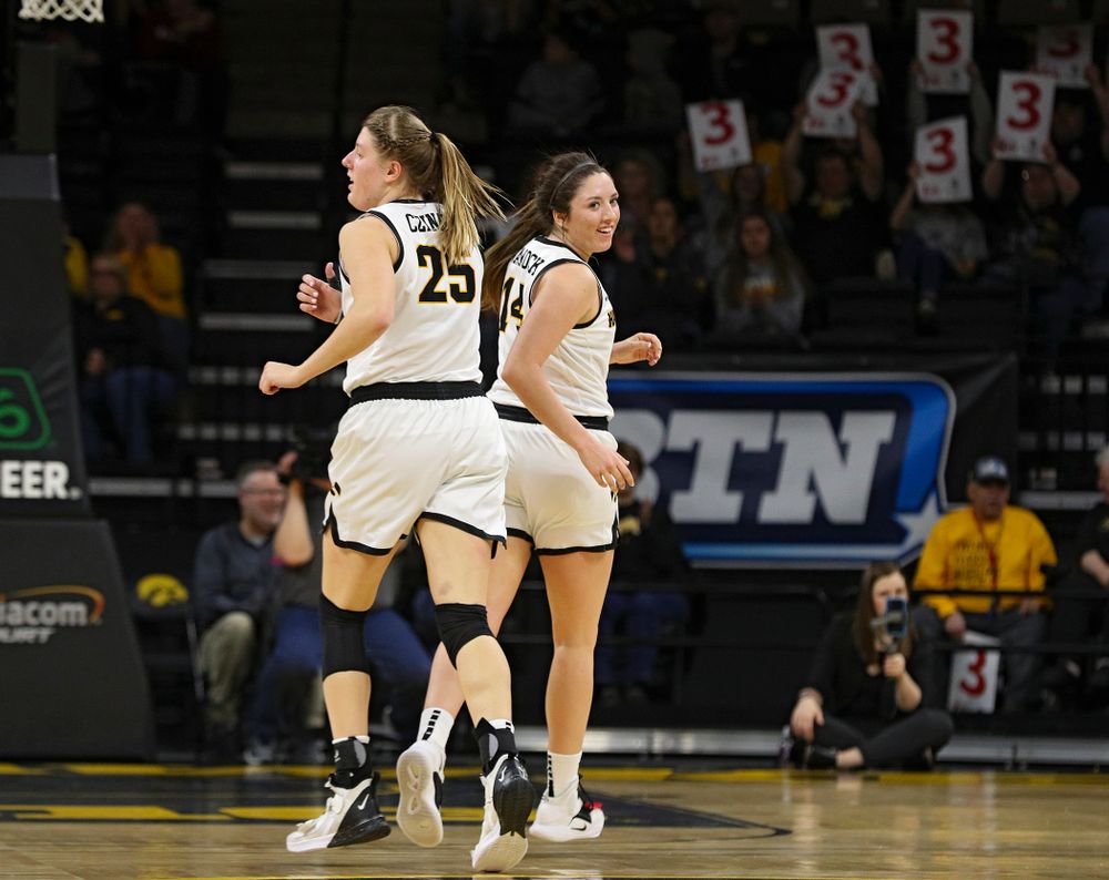 Iowa Hawkeyes guard Mckenna Warnock (14) smiles as she runs around forward Monika Czinano (25) after making a 3-pointer during the second quarter of their game at Carver-Hawkeye Arena in Iowa City on Sunday, January 26, 2020. (Stephen Mally/hawkeyesports.com)