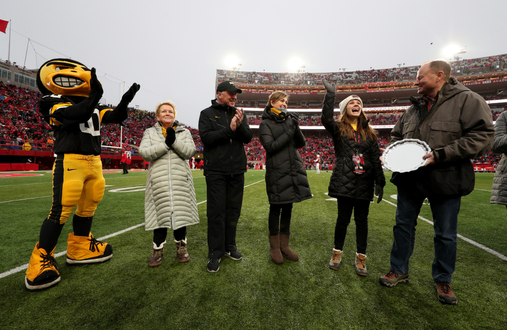 Iowa hero Katie Gudenkauf stands with Iowa Governor Kim Reynolds and Henry B. and Patricia B. Tippie Director of Athletics Chair Gary Barta as she is honored at half-time of the Iowa Hawkeyes game against the Nebraska Cornhuskers Friday, November 29, 2019 at Memorial Stadium in Lincoln, Neb. (Brian Ray/hawkeyesports.com)